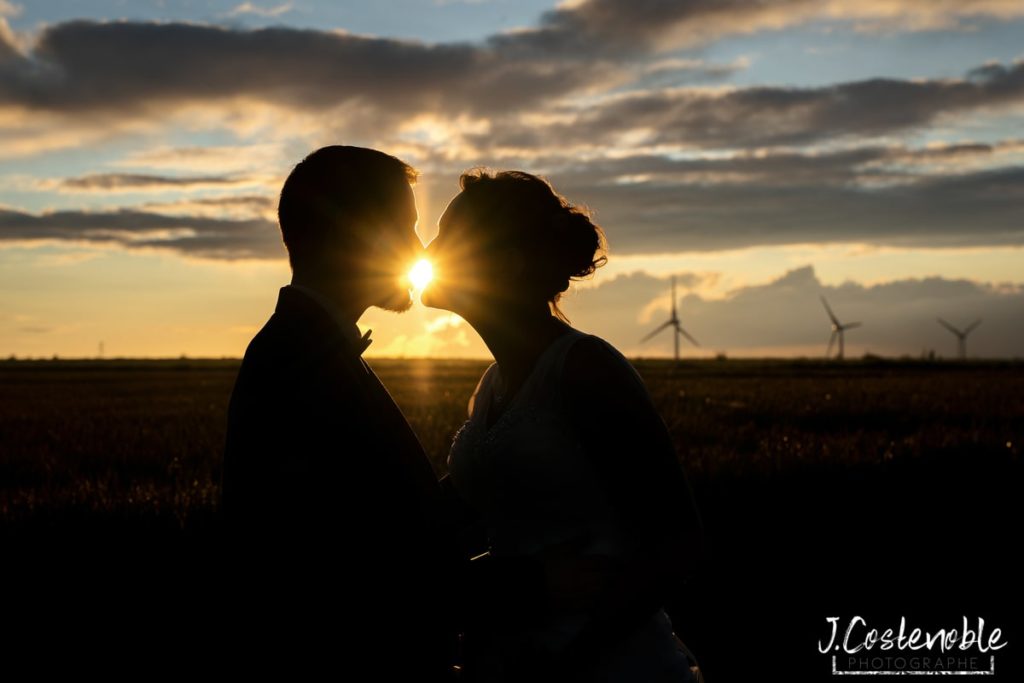 photo de couple au couche soleil avec éoliennes