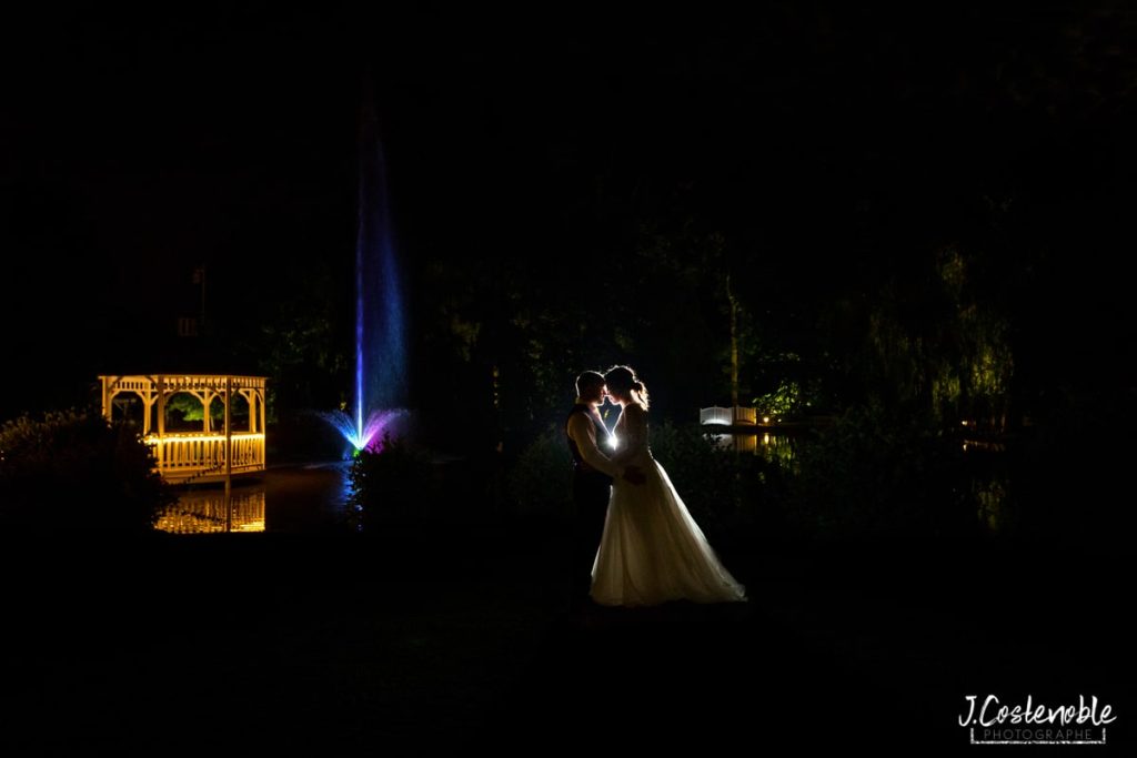 photo de couple de nuit devant une fontaine