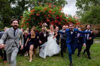 Photo fun d'un groupe d'invités du mariage qui courent vers le photographe.