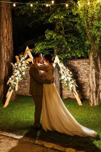 Couple de jeune mariés devant arche de cérémonie